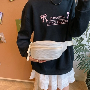 Close-up of white breathable mesh chest bag with adjustable strap worn on a black hoodie