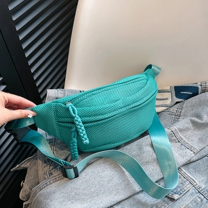 Detail of mint green mesh chest bag featuring woven zipper pulls and adjustable strap
