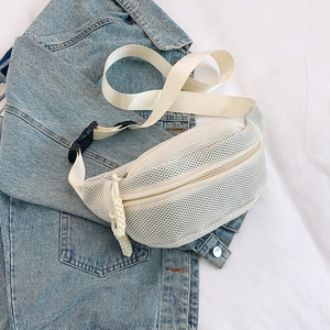 Detail of off-white mesh fanny pack with woven zipper pull over blue denim jacket