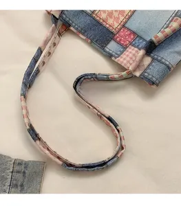 Detail of patchwork denim tote with pink floral patterns and smooth long shoulder straps