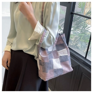 Detail of checkered canvas tote bag with purple patchwork and frayed edges craftsmanship