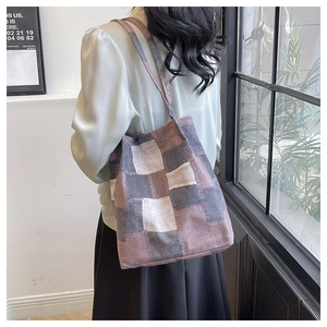 Detail of multi-color patchwork canvas tote bag with shoulder strap in soft natural light