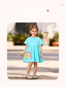 Detail of light blue cotton girls dress with vibrant rainbow and sun patch embroidery