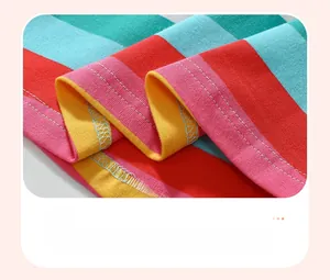 Gros plan détaillé de l'ourlet rayé arc-en-ciel avec des coutures fines sur robe fille