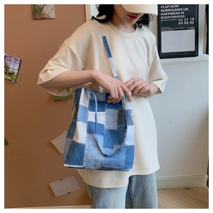 Detail of checkered denim tote bag with long shoulder straps and short handles