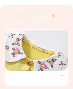 Détail de la robe en coton jaune avec double col blanc et broderies florales