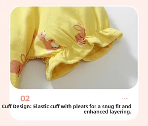 Détail de robe jaune en coton avec imprimé lapin rose et poignets élastiques froncés