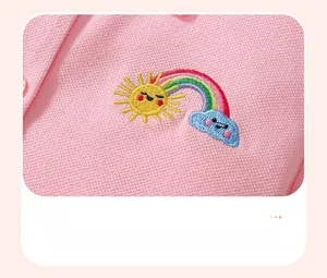 Dettaglio di un abito polo in cotone rosa con ricami di sole e arcobaleno di alta qualità