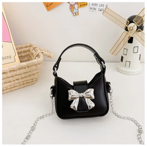 Detail of mini black handbag with silver metal bow and detachable silver chain strap