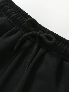 Short de sport noir pour garçon avec taille élastique et cordon de serrage en gros plan