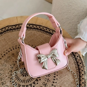 Pink mini crossbody bag with a large silver bow and chain strap for children