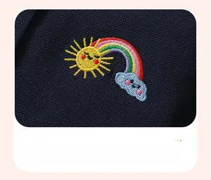 Dettaglio ricamo sole e arcobaleno su abito POLO in cotone blu scuro per bambina