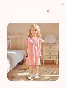 Dettaglio di un abito rosa in cotone da bambina con stampa cigno e volant bianchi