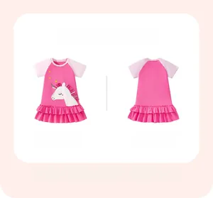 Detail of pink cotton girl's dress showing unicorn embroidery and ruffled hem