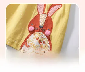 Détail d'une applique lapin brodée avec pompons 3D sur robe en coton jaune à pois