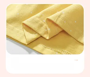 Gros plan détaillé de l'ourlet à double couture sur robe en coton à pois jaunes