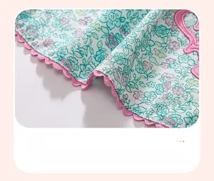 Detail of baby girl dress with floral patterns and pink scalloped wavy hemline