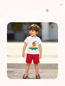 Dettaglio della maglietta bianca con stampa leone e coccodrillo e pantaloncini rossi casual