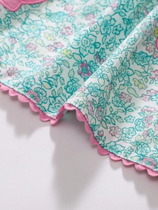 Cute girl's floral dress with scalloped pink edges and vibrant cartoon flower patterns