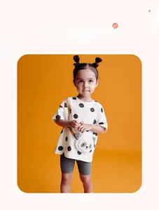 Toddler girl summer outfit with panda plush bag and polka dot tee in vibrant orange setting