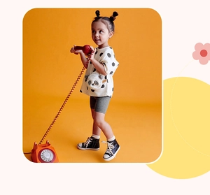 Detail of white polka dot t-shirt featuring a 3D panda crossbody bag and grey shorts