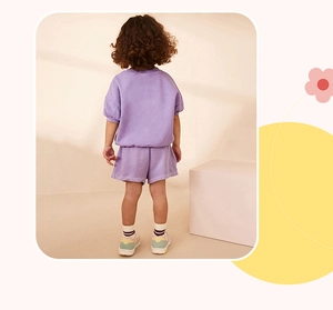 Vista trasera de un conjunto de verano para niñas con camiseta lavanda y pantalón corto