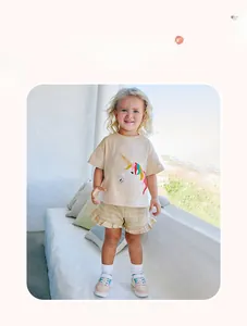 Girl's summer set with unicorn print t-shirt and striped ruffle shorts on a sunny patio