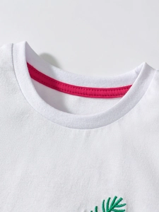 Maglietta bianca in cotone per bambini con nastro rosso e ricamo di foglie
