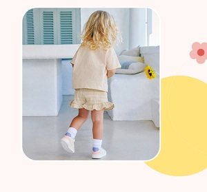 Rear view of a girls beige short-sleeve T-shirt and yellow striped ruffle shorts set