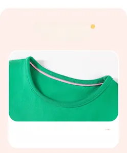 Detail of green cotton dress featuring pink contrast piping and fine stitching on neckline