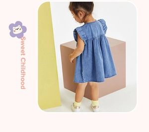 Dettaglio di abito in denim blu con maniche a volant e gonna a pieghe da bambina