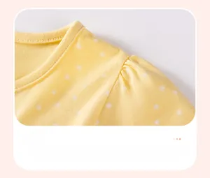 Detailed close-up of yellow cotton girls' dress featuring shoulder smocking and star prints