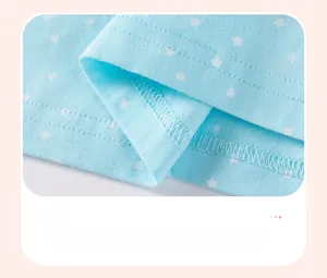 Detail view of the light blue cotton dress hem with white star print and double stitching