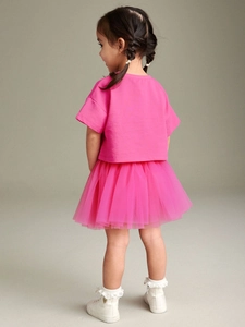 Back view of girl's bright pink summer two-piece set with t-shirt and mesh tutu skirt