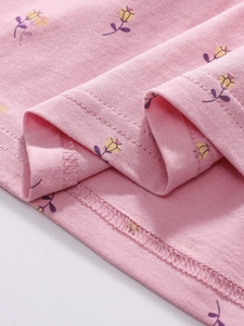 Gros plan du tissu en coton rose à fleurs avec une couture d'ourlet à double aiguille