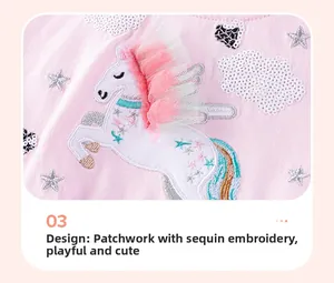 Détail d'une robe rose en coton avec broderie licorne et crinière en tulle et étoiles