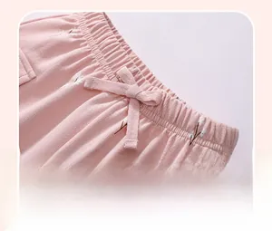Dettaglio dell'elastico in vita con fiocco rosa sui pantaloni in cotone a fiori da bimba