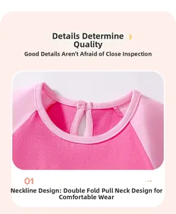 Détail du col en coton plié sur une robe rose à manches raglan pour tout-petit