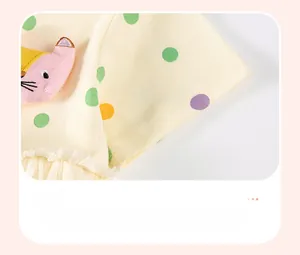 Détail de manche de robe en coton à pois avec broderie animale et bordure en tulle