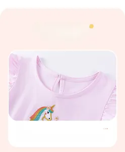 Dettaglio dello scollo in cotone rosa con ricamo unicorno e bottone sul retro