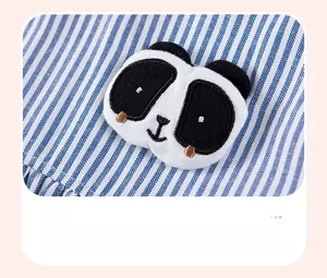 Nahaufnahme der 3D-Panda-Stickerei auf blau-weiß gestreiftem Baumwollstoff für Kinder