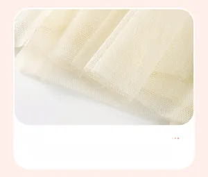 Détail de l'ourlet en tulle multicouche crème sur une robe d'été en coton pour fille