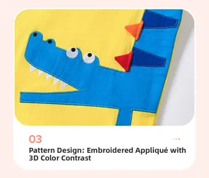 Détail de l'applique crocodile avec pointes 3D sur un ensemble jaune en coton pour garçon