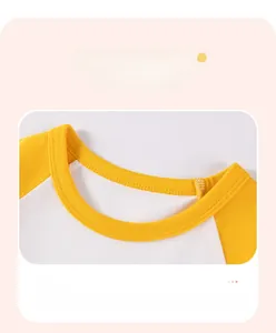 Détail du col rond côtelé doux sur le t-shirt raglan en coton jaune et blanc pour enfant