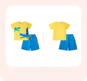 Détail de l'ensemble t-shirt jaune en coton et short bleu avec appliqué dinosaure