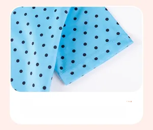 Detail of baby girl blue polka dot dress sleeve showing quality double-needle stitching