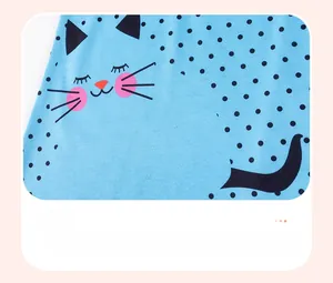 Close-up of a light blue cotton dress featuring black polka dots and a cute cat face design