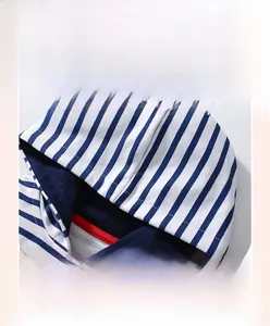 Detail of blue and white striped hoodie featuring a red contrast neck tape lining