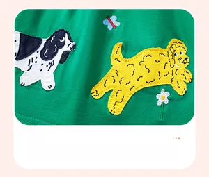 Detail of green cotton dress with embroidered cartoon dogs and butterfly appliques