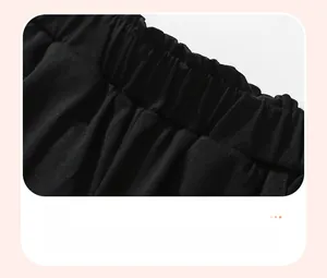 Close-up of the elastic waistband and pleated detailing on black cotton boy's pants